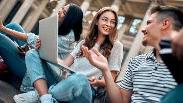 A group of students with laptops sit on the steps near the campus and communicate. (Bild: Adobe Stock) A group of students with laptops sit on the steps near the campus and communicate. (Bild: Adobe Stock)